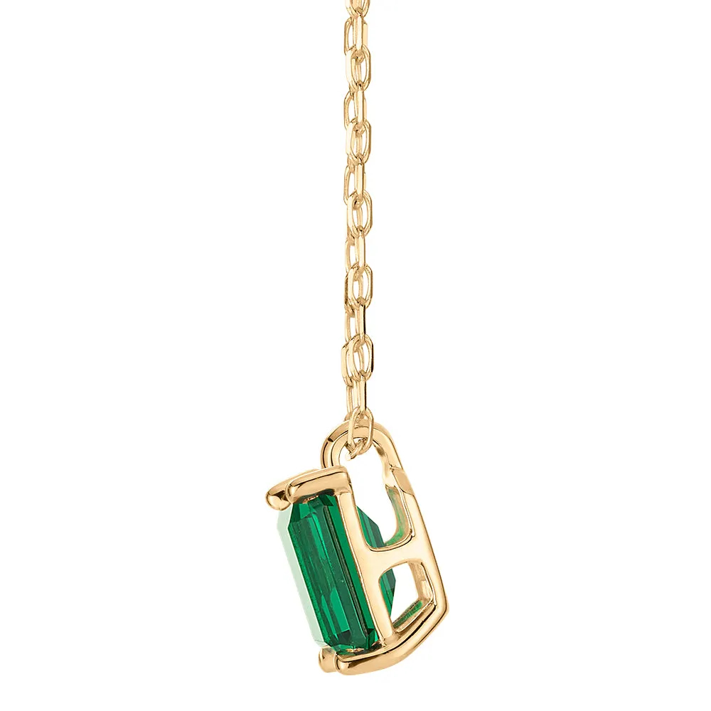 Emerald Cut solitaire pendant with emerald simulant in 10 carat yellow gold